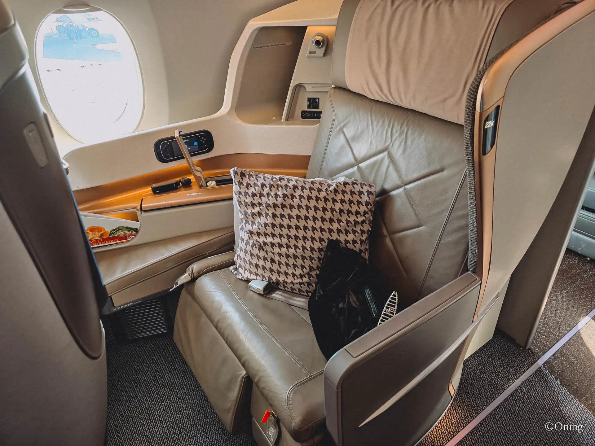 Singapore Airlines business class seat on the A350 with a houndstooth cushion by the window