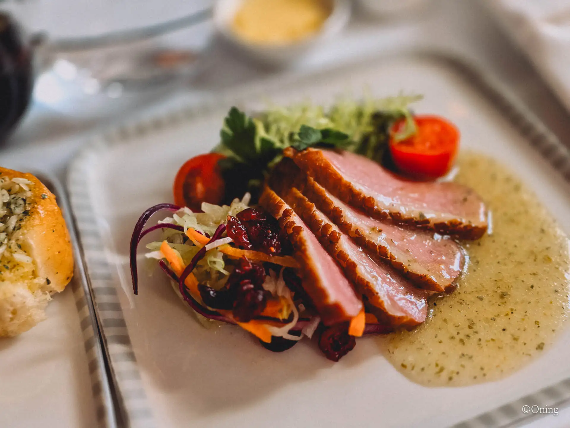 Smoked duck breast appetizer with salad and garlic bread on Singapore Airlines business class