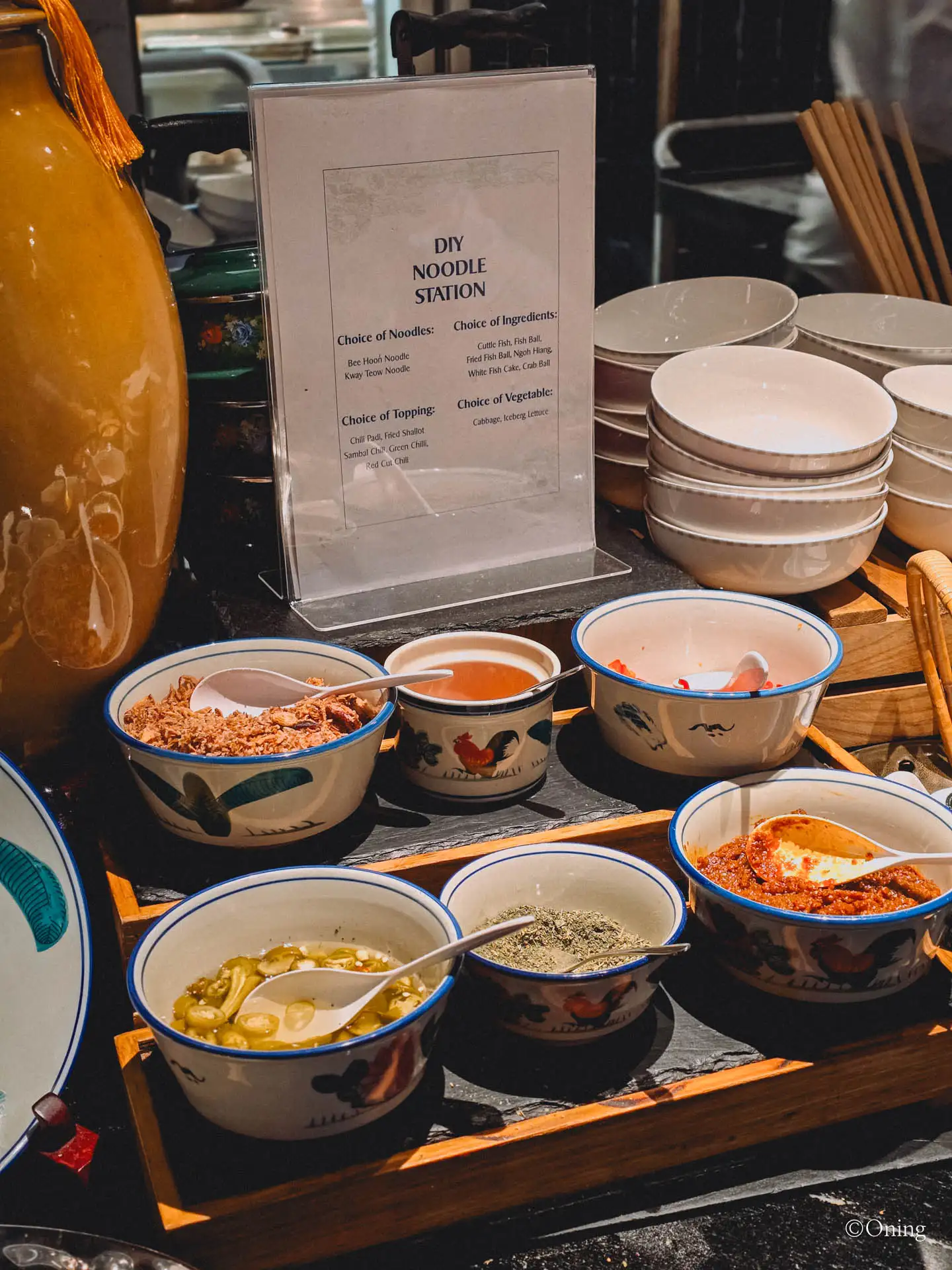 A DIY noodle station sign with bowls of toppings at the SilverKris Lounge