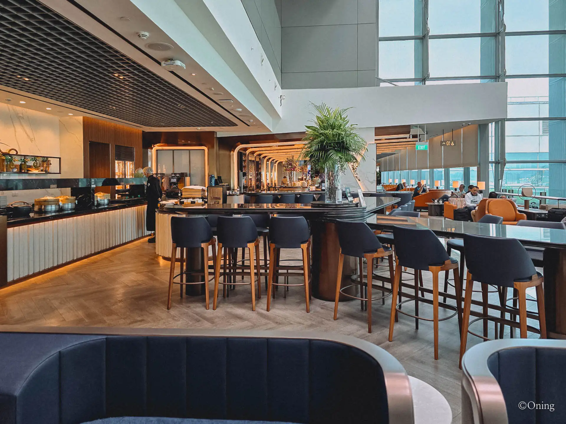 The quieter right-side lounge area with a bar and bright windows at Changi Terminal 3