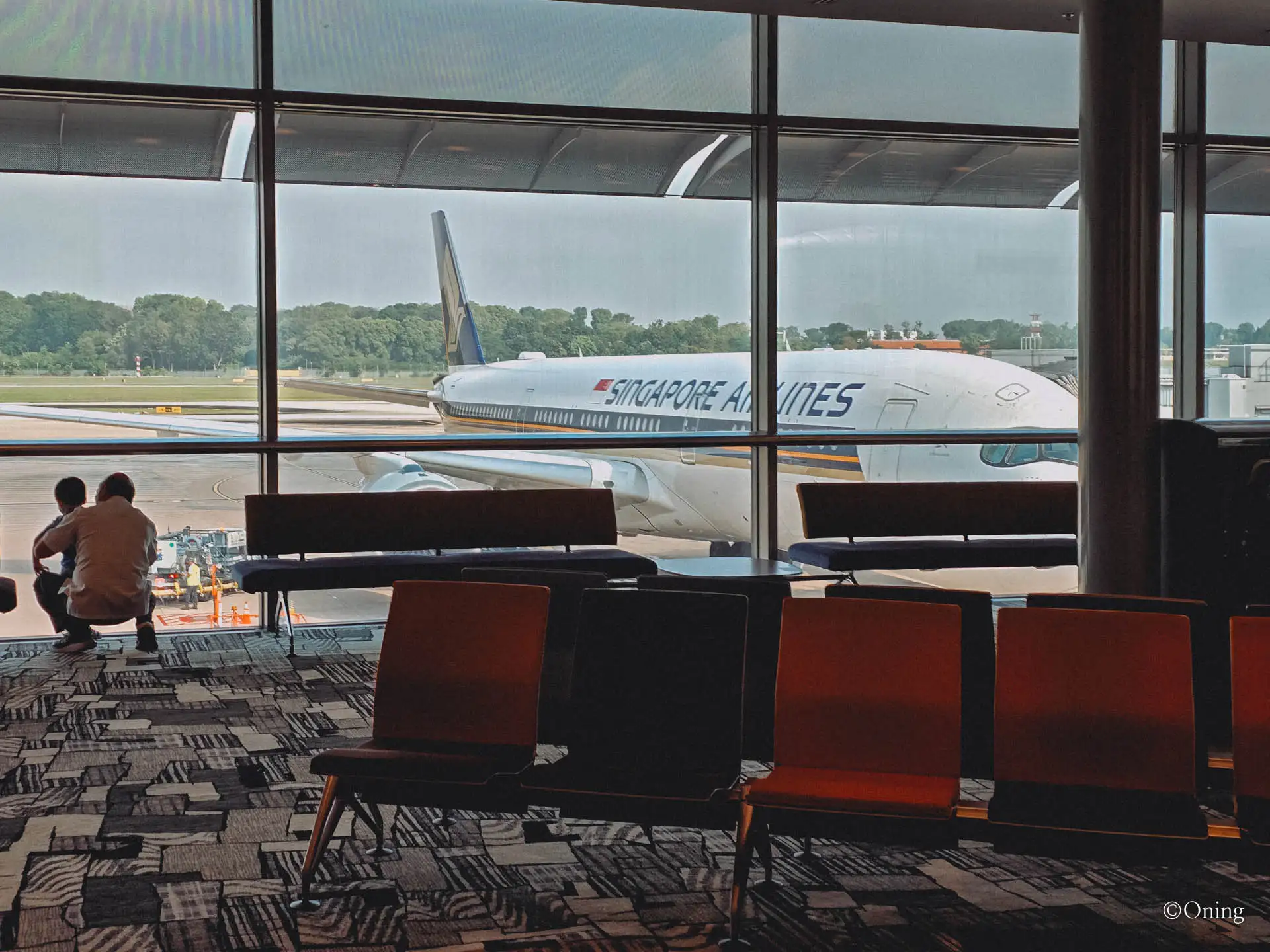 A Singapore Airlines aircraft parked at the gate seen from the Changi seating area