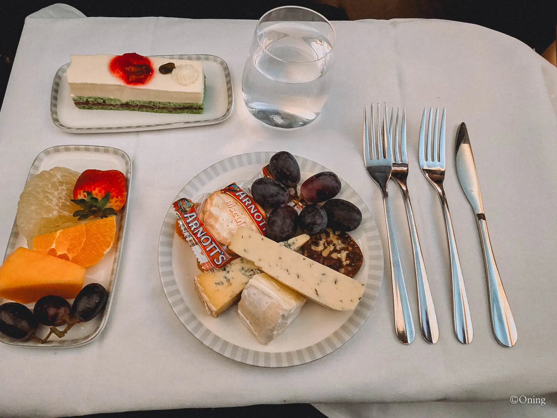 Dessert of pandan cake with a fruit and cheese plate on Singapore Airlines business class