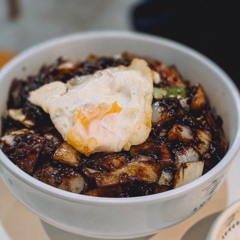 A bowl of Korean jajangmyeon topped with a fried egg, the easiest Korean-Chinese dish for first-timers