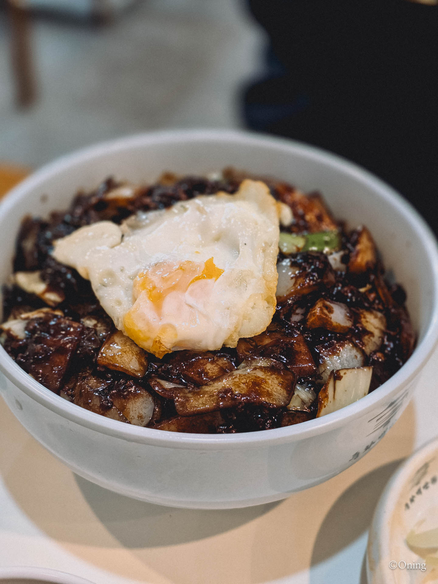 A bowl of Korean jajangmyeon topped with a fried egg, the easiest Korean-Chinese dish for first-timers